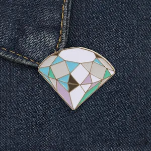 Close-up of geometric diamond enamel pin with pastel macaron colors on denim jacket