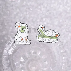 Gros plan de pins en émail de canard russe amusants posés sur un socle en verre