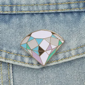 Detailed view of macaron colored diamond-shaped enamel pin badge on a denim jacket