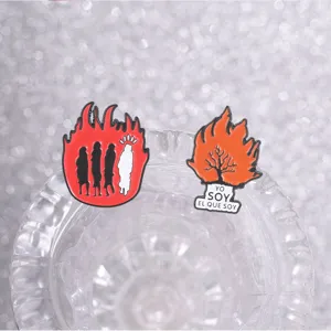Gros plan de pin's en émail flamme avec des silhouettes sur un verre en cristal