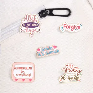 Collection of five Islamic enamel pins with religious quotes on white canvas background.