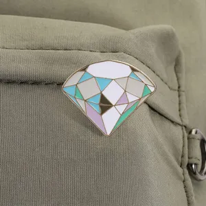 Macro view of macaron colored diamond enamel pin on canvas bag