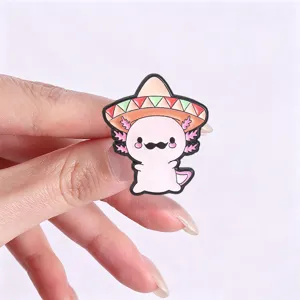 Close-up detail of a cute cartoon axolotl enamel pin wearing a Mexican sombrero hat