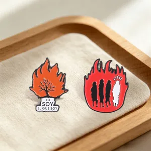Gros plan détaillé de broches émaillées avec des silhouettes de flammes et d'arbres