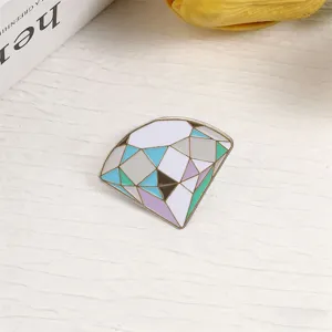 Macro detail of a geometric macaron diamond brooch pin on textured white background