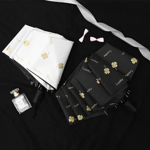 Three-fold anti-UV black glue umbrella with gold four-leaf clover lucky pattern printing