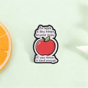 Detailed view of a funny red apple enamel pin featuring a humorous English quote.