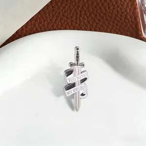 Gedetailleerde close-up van een vintage zwaard-emaille broche met 'You have my sword' lint