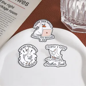 Gros plan de trois broches d'oies humoristiques avec citations spirituelles en anglais
