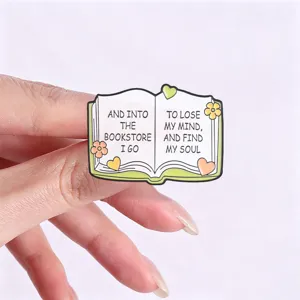 Close-up macro detail of a book-shaped enamel pin with a quote about bookstore and soul.