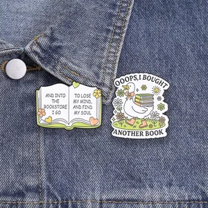 Close-up of funny duck and open book enamel pins pinned on a blue denim jacket