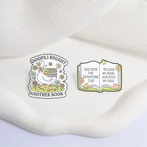 Macro view of cute white duck and open book enamel pins designed for book lovers