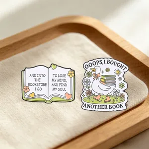 Detailed view of duck and open book enamel pins for book lovers' accessories