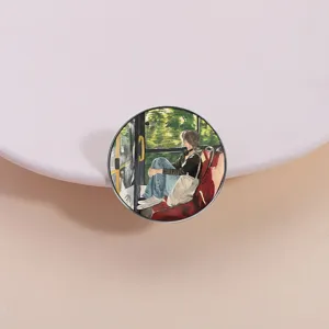 Detailed close-up of a round metal brooch featuring an artistic painted girl on a bus