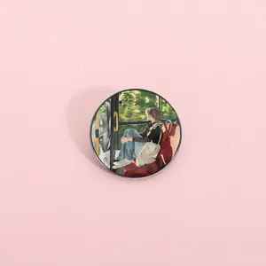 Detailed macro view of a circular metal badge pin featuring a girl on a bus illustration