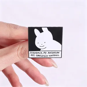 Dettaglio di una spilla smaltata minimalista con coniglietto e citazione inglese divertente.