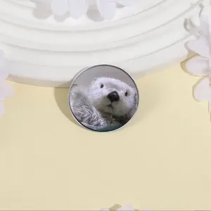 Jolie broche ronde en métal avec le portrait réaliste d'une loutre de mer blanche