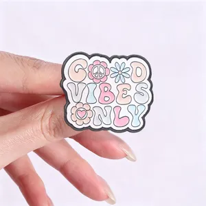 Close-up detail of retro 'Good Vibes Only' enamel pin with pink daisy and peace sign.