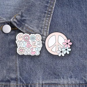 Retro hippie peace sign and Good Vibes Only enamel pins attached to denim jacket