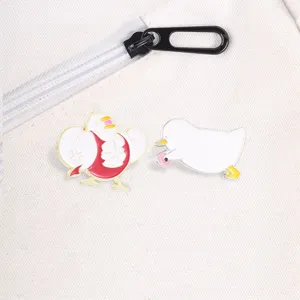 Vue détaillée d'épinglettes en émail de canard sur un sac en toile blanche.