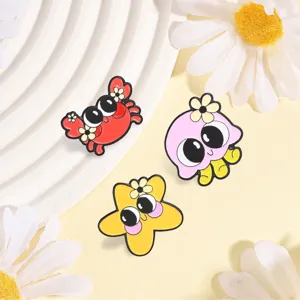 Close-up of cute cartoon ocean animal enamel pins including crab, octopus, and starfish