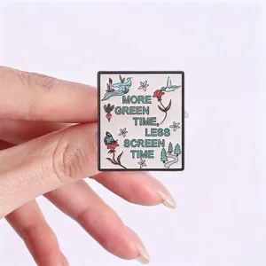 Detailed macro view of square enamel pin with More Green Time Less Screen Time quote