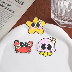 Detailed view of cute cartoon marine animal enamel pins including starfish, crab and octopus.