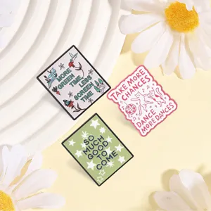 Detail view of motivational enamel pin badges featuring dancing cats and nature quotes