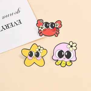 Close-up of cute cartoon ocean animal enamel pins featuring crab, starfish, and jellyfish.