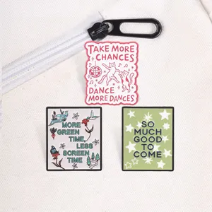 Close-up of three motivational metal enamel pins featuring dancing cats and nature quotes