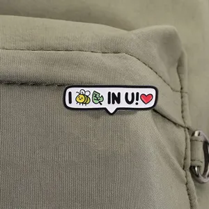 Close-up van een schattige emaille speld met bij en blad op een groene tas.
