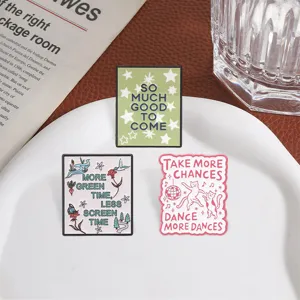 Close-up of three motivational metal enamel pins with cat, nature, and star designs