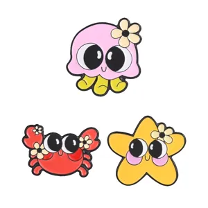 Set of three cute cartoon sea animal enamel pins featuring octopus, crab, and starfish.