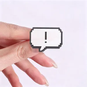 Close-up of retro pixel art speech bubble pin with exclamation mark on white back.