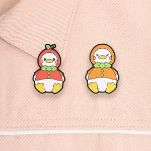 Detailed macro view of cute cartoon duck enamel pins in apple and orange fruit costumes