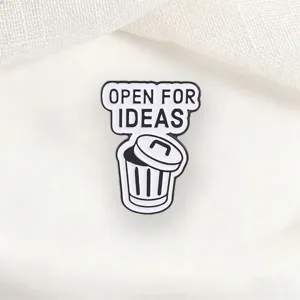 Detail macro view of quirky trash can metal enamel pin with 'Open For Ideas' quote