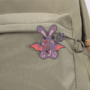 Gros plan d'un pin's en émail lapin violet effrayant sur un sac à dos en toile verte