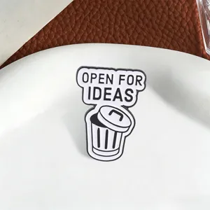 Macro detail view of 'Open For Ideas' funny trash can enamel pin with black outlines