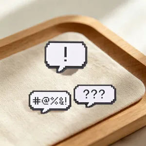 Detailed view of pixelated speech bubble enamel pins with retro video game symbols