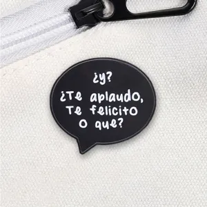 Close-up detail of a funny Spanish speech bubble enamel pin on a white canvas bag