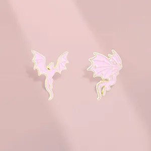 Close-up of pink and gold flying dragon enamel pins with star details for backpacks.