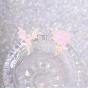 Detailed macro view of pink and gold enamel dragon pins featuring star patterns