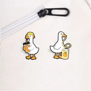 Close-up detail of funny cartoon white goose enamel pins on a white canvas bag zipper