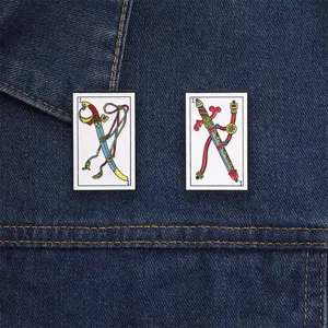 Set vintage Tarot Zwaard emaille speldjes op een blauw denim jack detail gepresenteerd