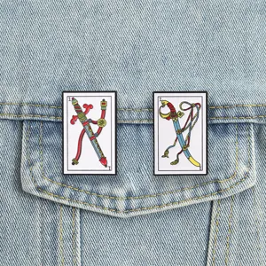 Detail van vintage tarotspelden met zwaardmotieven op een spijkerjaszak.