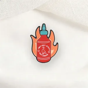 Funny hot sauce bottle enamel pin with flame and duck logo for backpacks and jackets.