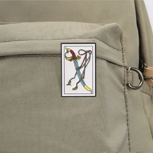 Detailopname van een vintage Tarot zwaard emaille speld op een kaki stoffen rugzak.