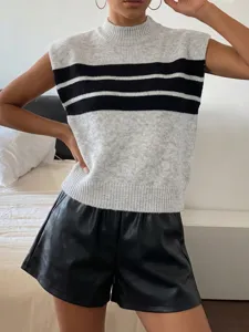 Detailed view of women's striped mock neck sweater vest styled with leather shorts