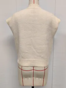 Back view of a cream mock neck knitted vest on a mannequin showing knit texture.