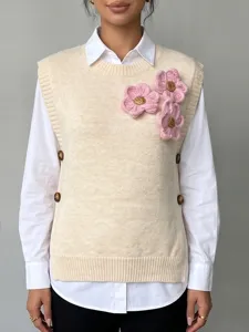 Primer plano del chaleco de punto de lana con flores 3D rosas, cuello redondo y botones.